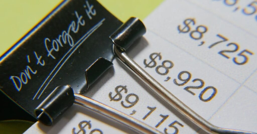 Close-up image showcasing a binder clip on a detailed financial report with highlighted amounts.