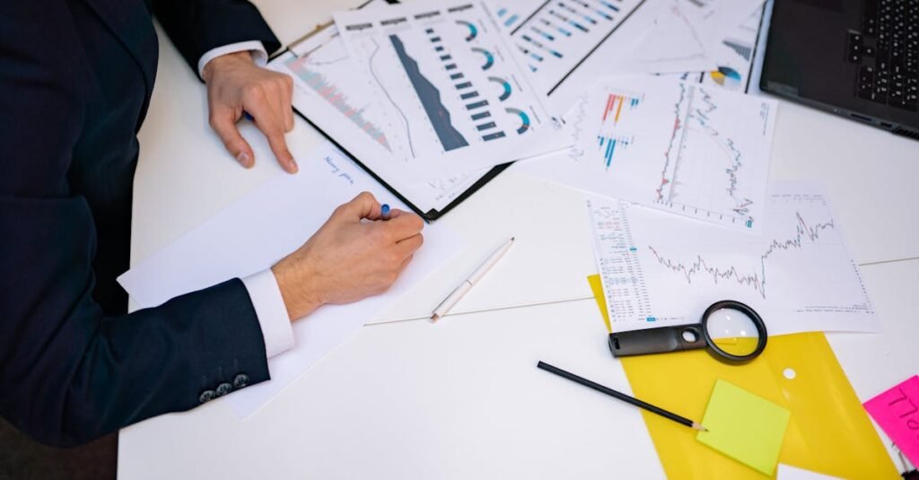 Will 2026 Be the Year the Housing Market Finally Crashes? Close-up of a desk cluttered with financial charts, graphs, and reports, perfect for business and finance themes.