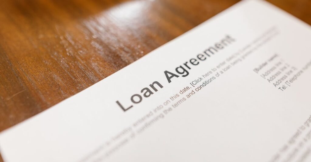 Detailed loan agreement document close-up on a wooden table representing legal and financial concepts.